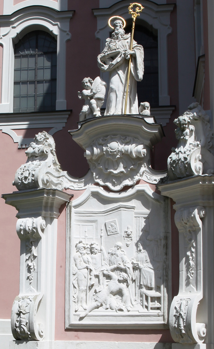 Kirchenportal links: Figur und Steinrelief: Mönchsvater Benedikt