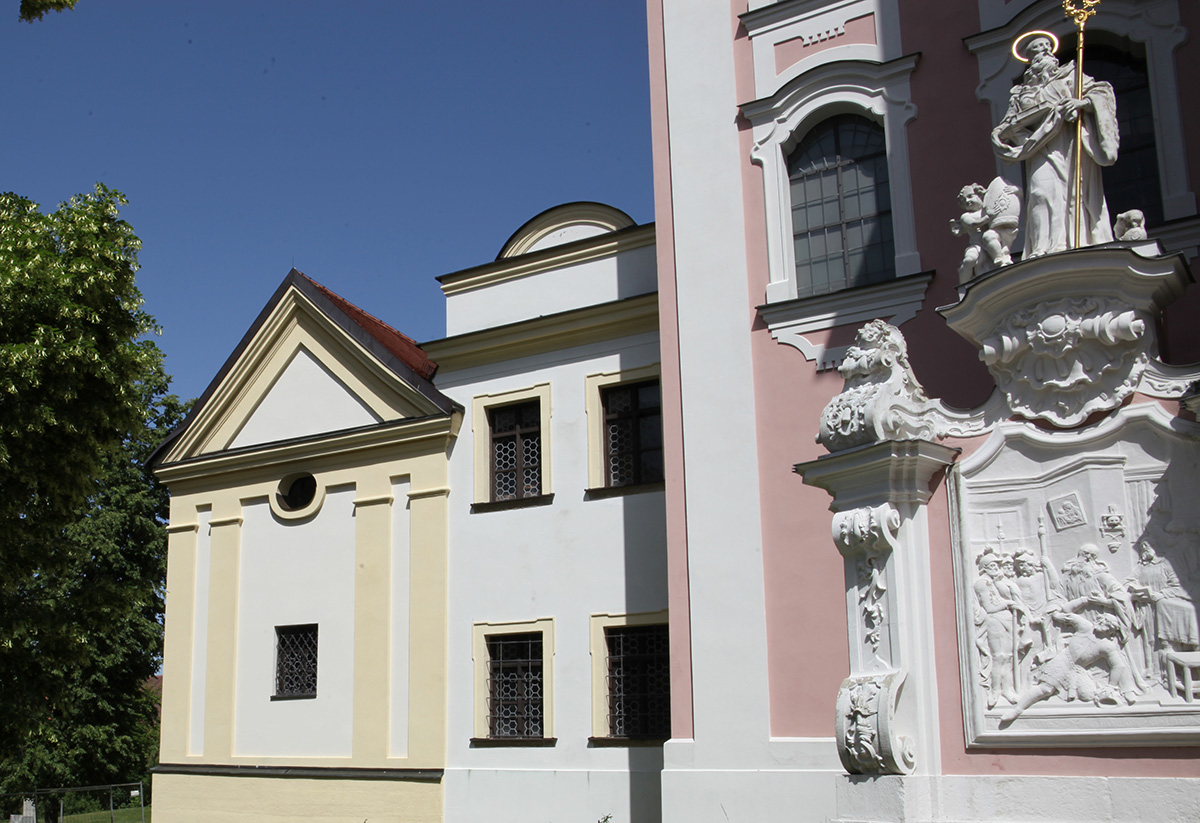 Kirchenportal links: Fassadenmauer und Loretokapelle