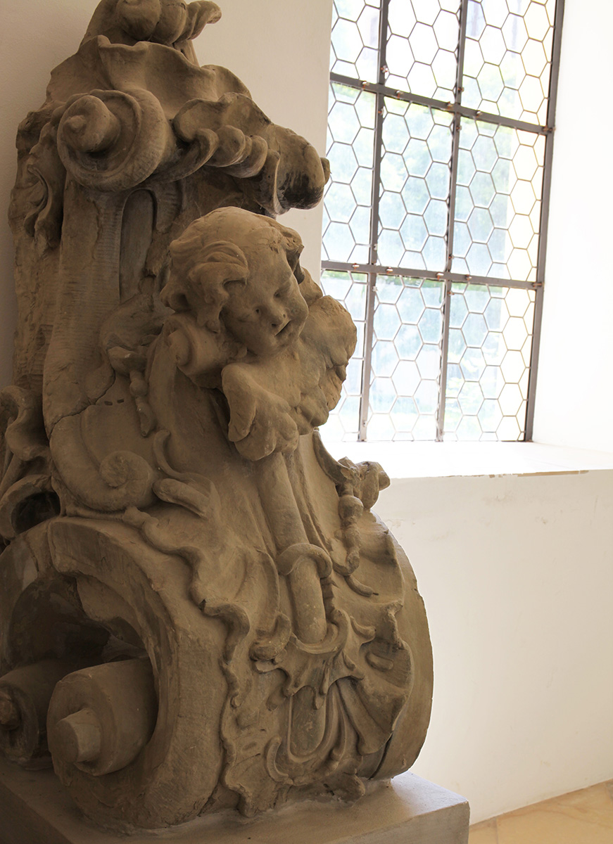 Nördlicher Kreuzgangarm: Sandsteinskulptur der Kirchenfassade